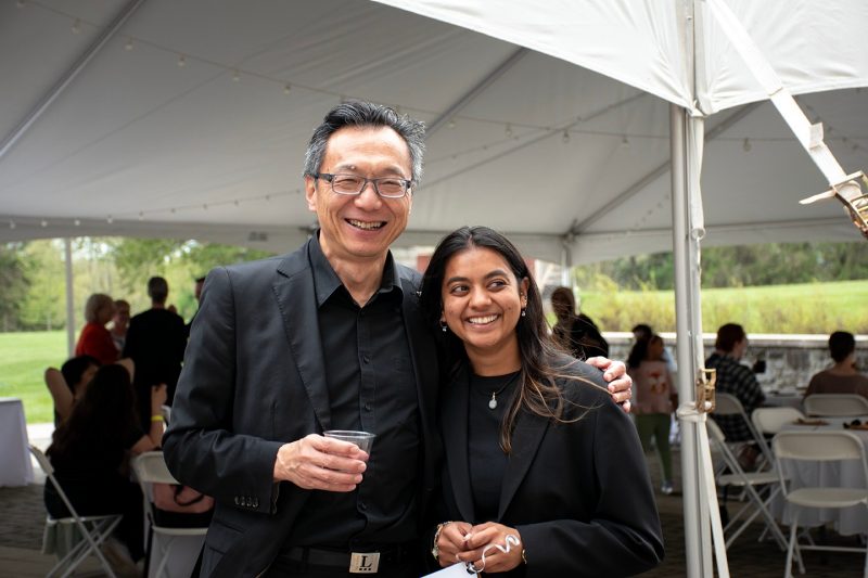 Dean Liu with a young alum at graduation party.