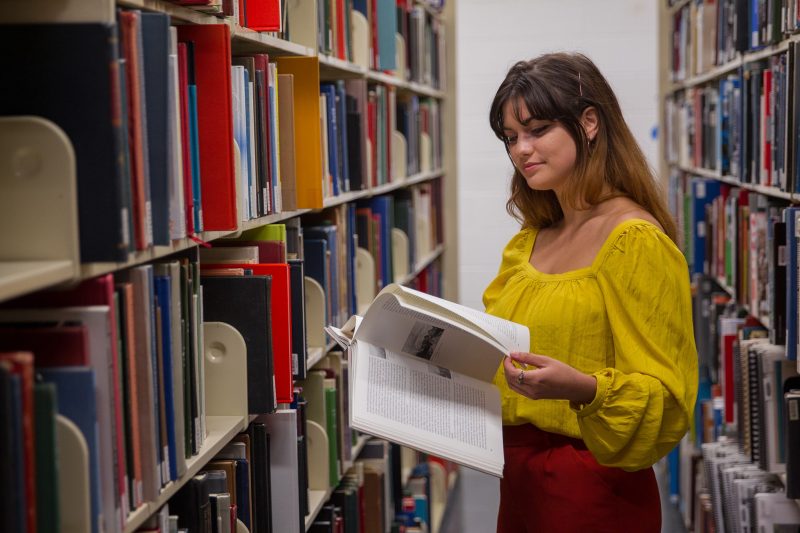 Student looking at book in library 