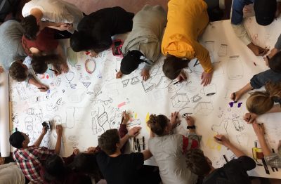 Overhead of students drawing together on one long piece of paper