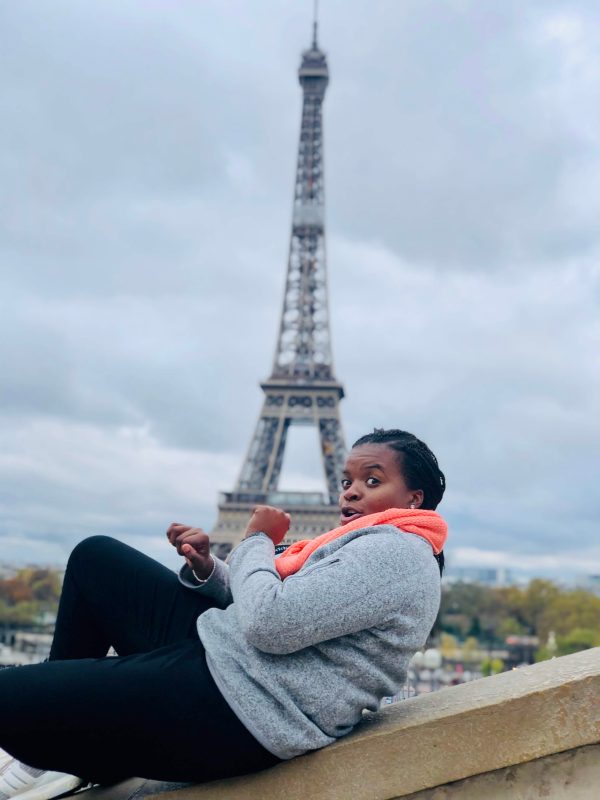 Sheema posing in front of the Eiffel Tower in Paris.
