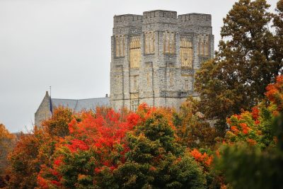 Trees with bright orange fall leaves in front of Burruss Hall