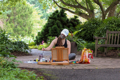 An art students paints at the Hahn Horticulture Garden during COVID-19