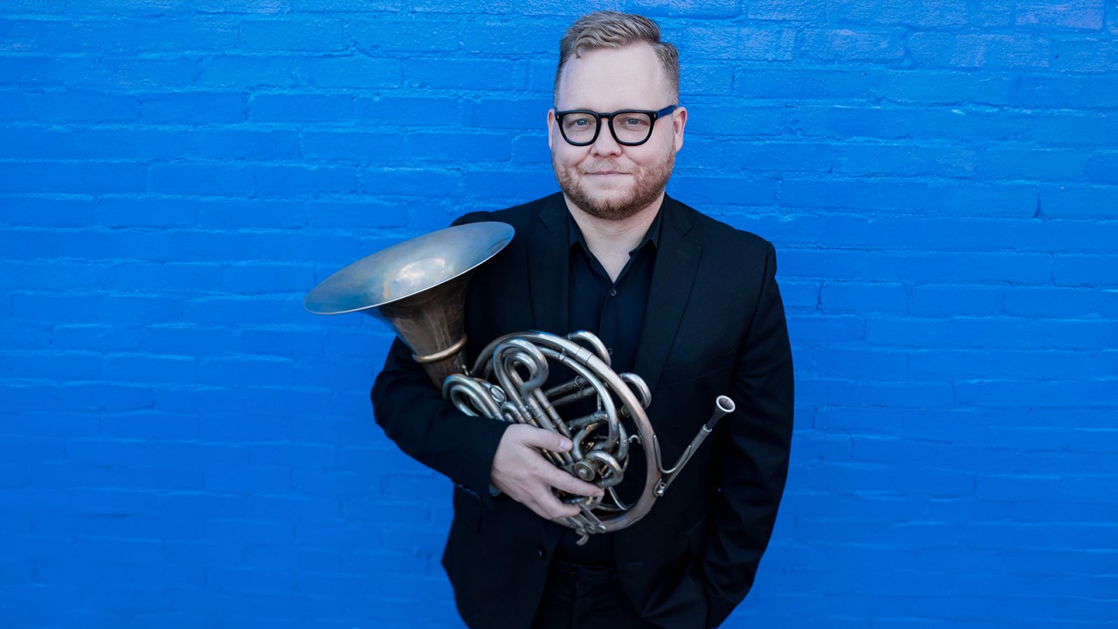 Dakota Corbliss headshot; holding french horn
