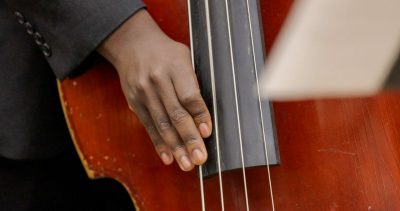 Hand playing musical instrument.