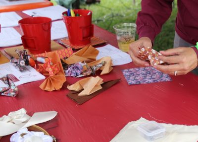 Guest folds origami at tailgate.