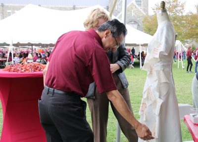 Dean Liu pinning fabric to mannequin at tailgate.