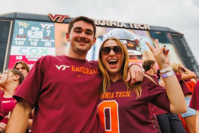 Two students smiling in the student section at the Homecoming game against Wake Forest.