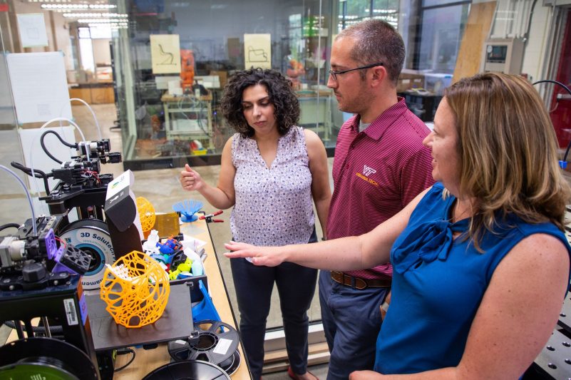 Faculty discuss possible fabrication methods in the 3D printing lab