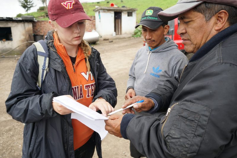 Madi Dynes looks at a list of farms with Ecuadorian partners during survey fieldwork.
