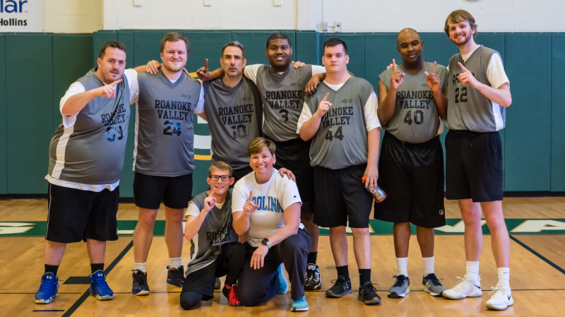 Team photo of Roanoke Grizzlies Special Olympics basketball team with players holding No. 1 finger up.